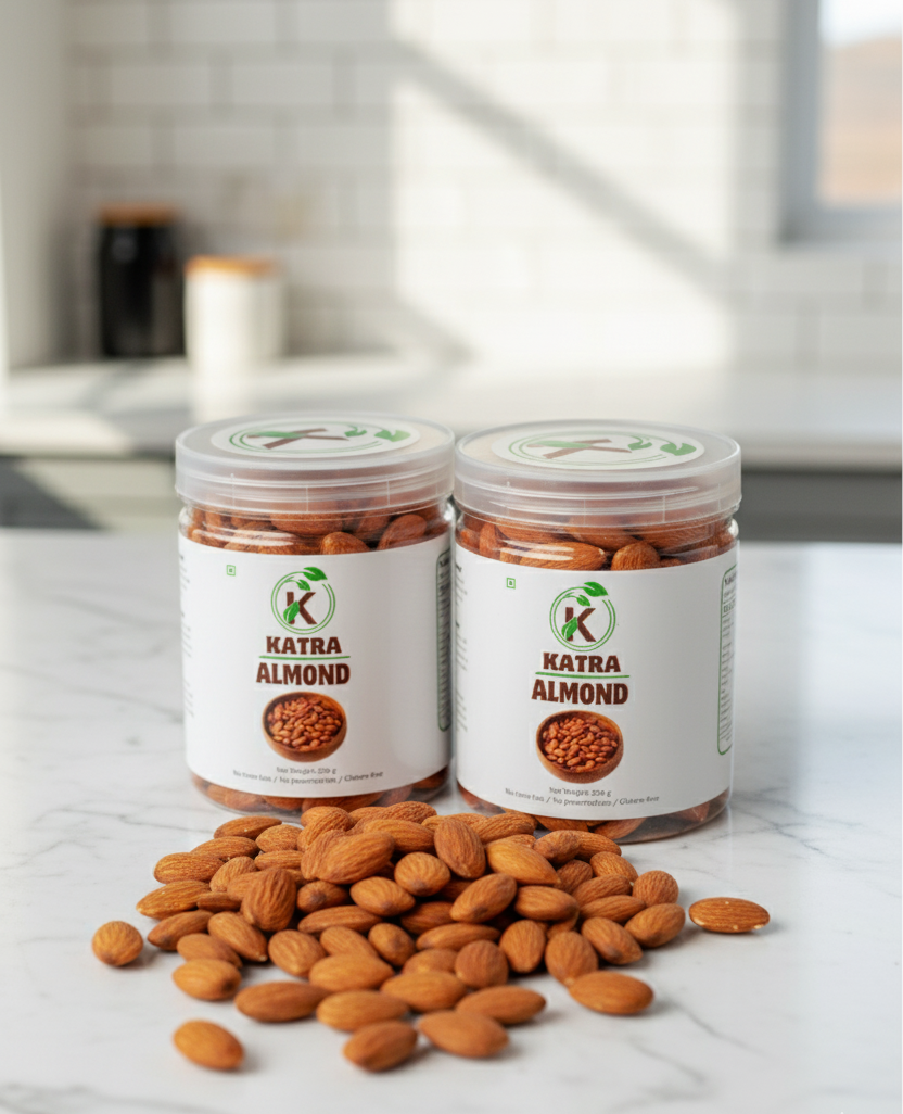 Two jars of Katra Almond on a marble surface with almonds scattered around.